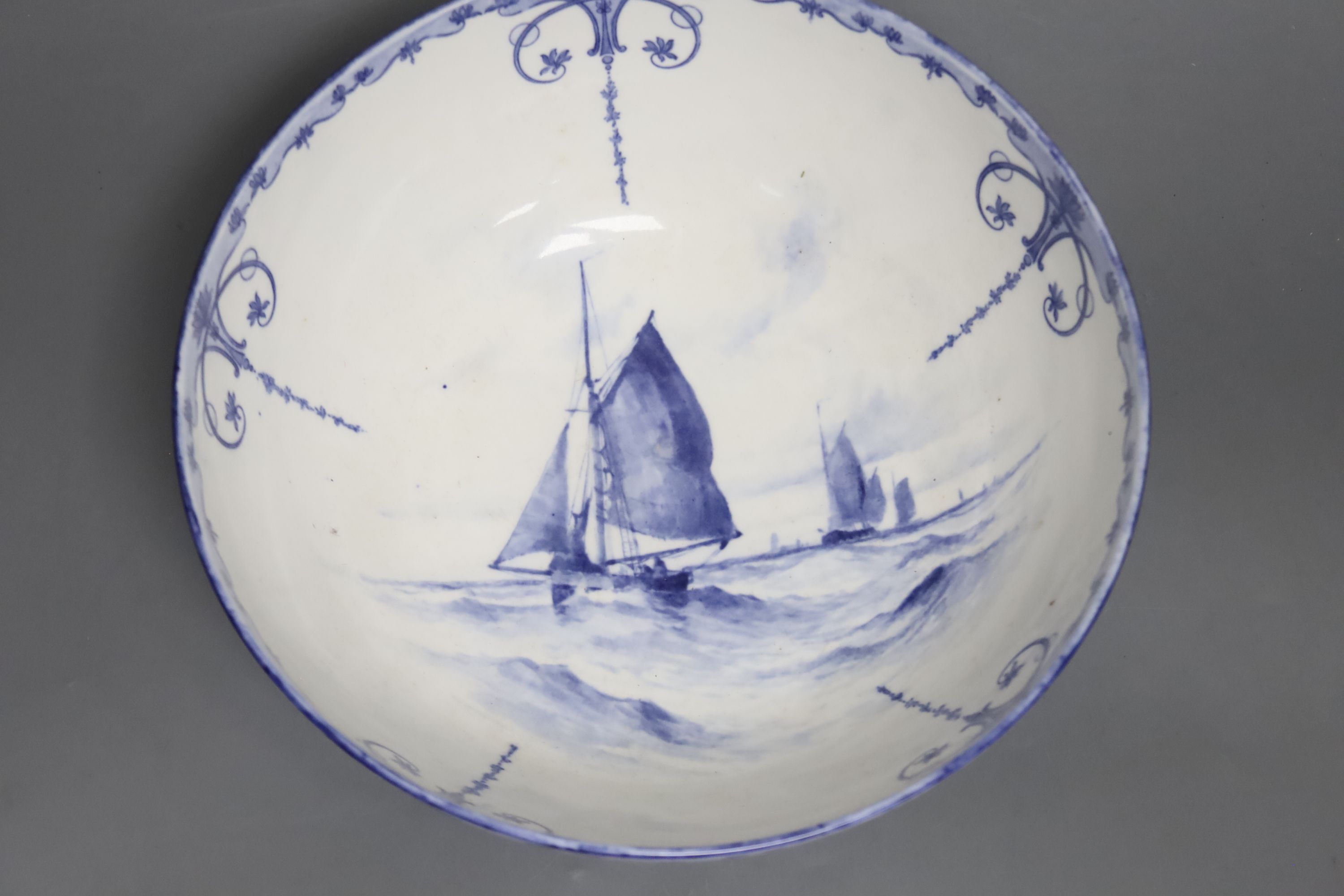 A Royal Crown Derby blue and white bowl painted with sailing scenes, by W.E.J. Dean, diameter 23cm